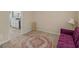 Sitting area with carpet, a purple futon, a decorative circular rug, and a view into the kitchen at 71 Russell Rd, Mcdonough, GA 30252