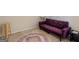 Sitting area with carpet, a purple futon, and a decorative circular rug at 71 Russell Rd, Mcdonough, GA 30252