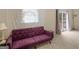 Sitting area with a large purple futon, carpet, and patio doors at 71 Russell Rd, Mcdonough, GA 30252