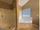 Bathroom featuring a jacuzzi tub, shower, and window for natural light at 159 Courtneys Ln, Fayetteville, GA 30215