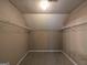 A walk-in closet with beige walls, carpeted floors, and wire shelving, illuminated by a central light at 159 Courtneys Ln, Fayetteville, GA 30215