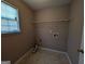 Bright laundry room features ample space and a shelf for added storage solutions at 159 Courtneys Ln, Fayetteville, GA 30215