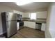 Modern kitchen with stainless steel appliances, granite countertops, white cabinets, and wood-look flooring at 1923 Rosewood Rd, Decatur, GA 30032