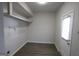 Well-lit room with hardwood style flooring, door and shelving for storage at 2509 Appomattox Dr, Decatur, GA 30034