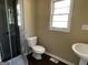 Bathroom boasts tile shower, toilet, and pedestal sink with dark hardwood floors at 1271 Sanders Dr, Lake City, GA 30260