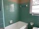 Bathroom showcasing vintage tile work and a soaking tub below a window at 1271 Sanders Dr, Lake City, GA 30260