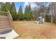 Large backyard with mature trees and a playset featuring a slide and swing set at 1301 Blue Sky Ct, Peachtree City, GA 30269
