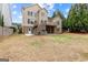 Expansive backyard with a deck, patio, and lush lawn surrounding a tan two-story home at 1301 Blue Sky Ct, Peachtree City, GA 30269