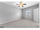 Spacious bedroom featuring neutral carpet and paint, ceiling fan, and a window offering natural light at 1301 Blue Sky Ct, Peachtree City, GA 30269