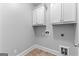Functional laundry room with white cabinets, neutral walls, and tile flooring providing a clean and organized space at 1301 Blue Sky Ct, Peachtree City, GA 30269
