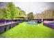 Private backyard oasis with a kidney-shaped pool, turf lawn, dining area, and lounge seating for entertaining at 4450 Sterling Forest Dr, Decatur, GA 30034