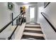 Modern staircase with black railing and a glass partition, leading to a bright entryway with natural light at 4450 Sterling Forest Dr, Decatur, GA 30034