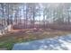 Large, tree-lined backyard with wooden fence and concrete patio at 8030 Snapwell Dr, Fairburn, GA 30213
