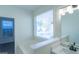 Bright bathroom featuring a soaking tub with a window view and modern vanity at 8030 Snapwell Dr, Fairburn, GA 30213