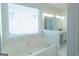 Bathroom with garden tub under window and double sink vanity with elegant lighting at 8030 Snapwell Dr, Fairburn, GA 30213