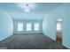 A bonus room with neutral walls, carpeted floors and three windows at 8030 Snapwell Dr, Fairburn, GA 30213