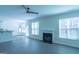 Bright living room featuring modern ceiling fan, gas fireplace, light grey flooring, and large windows at 8030 Snapwell Dr, Fairburn, GA 30213