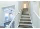 Staircase leading to the second floor; view of dining room with modern light fixture at 8030 Snapwell Dr, Fairburn, GA 30213