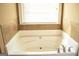 Bright bathroom featuring a soaking tub with tiled backsplash and a window providing ample natural light at 1109 Norsworthy Ml, Hampton, GA 30228