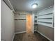 Bedroom featuring carpeted floors, open closet, and built-in shelves, offering storage and organization at 125 Mcintosh Estates Dr, Sharpsburg, GA 30277