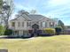 Charming two-story home featuring a manicured front lawn, decorative shutters, and a welcoming front entrance at 125 Mcintosh Estates Dr, Sharpsburg, GA 30277
