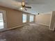 Spacious living room showcasing plush carpet, two ceiling fans, and bright windows, perfect for relaxation at 125 Mcintosh Estates Dr, Sharpsburg, GA 30277