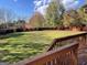 Scenic backyard view from a wooden deck, showcasing a well-maintained lawn and mature trees at 239 Overland Trl, Mcdonough, GA 30252