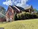 Spacious brick home featuring a large lawn, mature landscaping, and an attached garage at 239 Overland Trl, Mcdonough, GA 30252