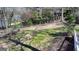 Lush backyard with mature trees, a wooden fence, and partial views of the lake at 4852 Jacobs Cove Pt, Buford, GA 30519