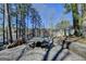 Outdoor patio with dining set overlooking the lake, surrounded by lush trees at 4852 Jacobs Cove Pt, Buford, GA 30519
