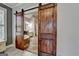 Bathroom featuring barn door access with stone floors and a modern soaking tub at 4852 Jacobs Cove Pt, Buford, GA 30519