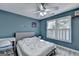 bedroom with blue walls, dinosaur-themed bedding, and a bright window view at 4852 Jacobs Cove Pt, Buford, GA 30519