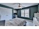Cozy bedroom with a ceiling fan, built-in desk, and a large window overlooking a scenic view at 4852 Jacobs Cove Pt, Buford, GA 30519