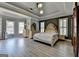 Bright main bedroom with large windows, tray ceiling, and stylish furnishings at 4852 Jacobs Cove Pt, Buford, GA 30519