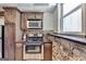 Cozy kitchen featuring stainless steel appliances, tile backsplash, and a stone accent wall at 4852 Jacobs Cove Pt, Buford, GA 30519