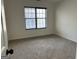 Neutral carpeted bedroom with natural light from large window and mini blinds for privacy at 1126 Old Jackson Rd, Locust Grove, GA 30248