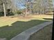 Well-maintained front yard featuring green grass, mature trees, and a paved walkway at 1126 Old Jackson Rd, Locust Grove, GA 30248