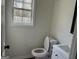 A half bathroom with white vanity and a window letting in plenty of natural light at 1126 Old Jackson Rd, Locust Grove, GA 30248