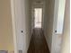 Hallway with clean walls, contrasting doors, and carpeted bedrooms at the end at 1126 Old Jackson Rd, Locust Grove, GA 30248
