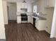 Well-lit kitchen boasts sleek stainless-steel appliances, white cabinets and wood-look flooring at 1126 Old Jackson Rd, Locust Grove, GA 30248