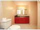 A view of the bathroom featuring a sink with red cabinets and tiled flooring at 35 East Honeysuckle Ln, Carrollton, GA 30116