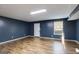 Large basement space with blue accent wall, hardwood floors, and a window at 217 Old Carrollton Rd, Carrollton, GA 30116