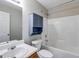 Bright bathroom featuring a shower-tub combo with a blue storage cabinet above the toilet at 217 Old Carrollton Rd, Carrollton, GA 30116