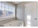 Bright bathroom featuring a soaking tub and a window at 217 Old Carrollton Rd, Carrollton, GA 30116