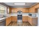 Well-lit kitchen with stainless steel appliances, ample counter space, and classic wooden cabinets at 217 Old Carrollton Rd, Carrollton, GA 30116