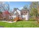 Side view of a white two-story home with a lawn and wooden staircase leading to the front door at 275 Cedars Glen Cir, Villa Rica, GA 30180