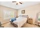 Bright bedroom featuring a ceiling fan, window, clock, and comfortable neutral-toned furniture at 275 Cedars Glen Cir, Villa Rica, GA 30180
