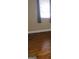 Close up view of bedroom with hardwood flooring, showing window and baseboards at 2563 Highway 81 E, Mcdonough, GA 30252