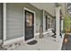Inviting covered porch with seating, stylish door, black shutters and manicured landscaping at 205 Valley View Dr, Tyrone, GA 30290