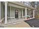 Inviting covered porch with seating, stylish door, black shutters and manicured landscaping at 205 Valley View Dr, Tyrone, GA 30290